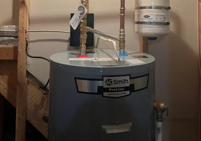 A.O. Smith ProLine water heater in a utility closet with copper pipes and an expansion tank.