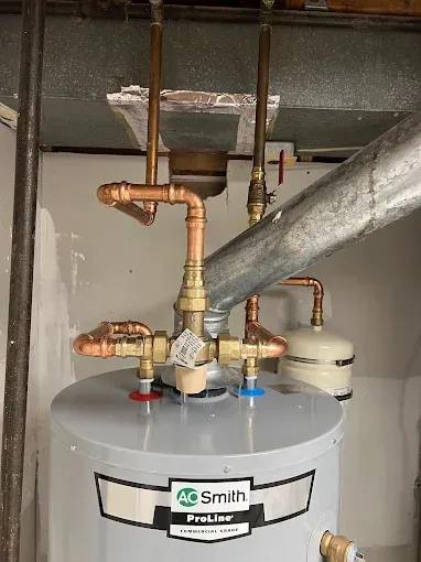 A.O. Smith ProLine water heater with copper plumbing connections in a utility room.
