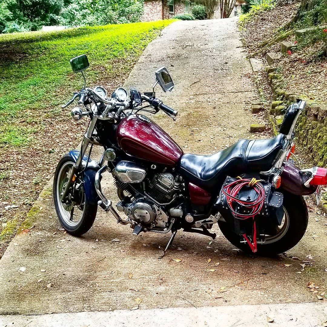 A red motorcycle is parked on the side of a road.