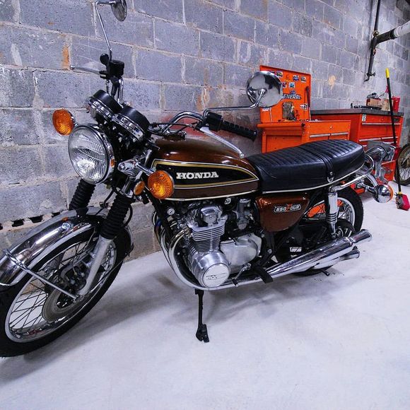 A green and black motorcycle is parked in a garage.