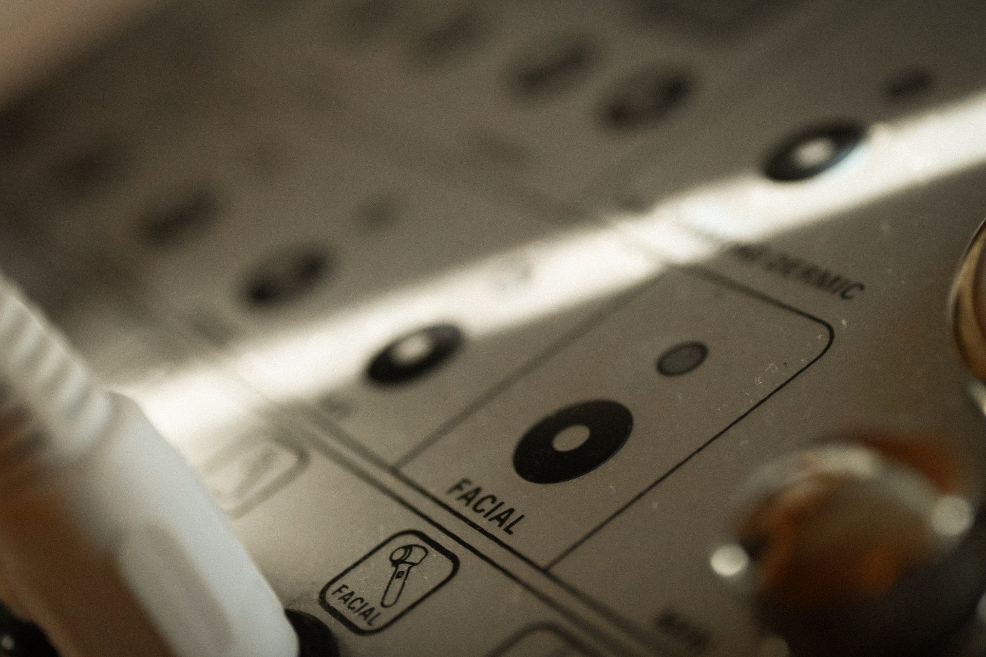 A close up of a facial machine with a button that says facial