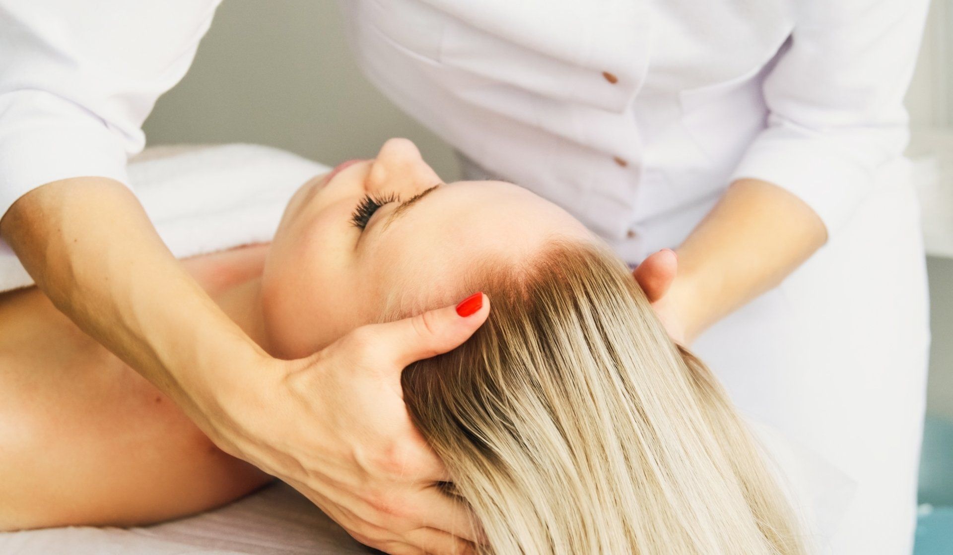 A woman is getting a head massage at a spa.