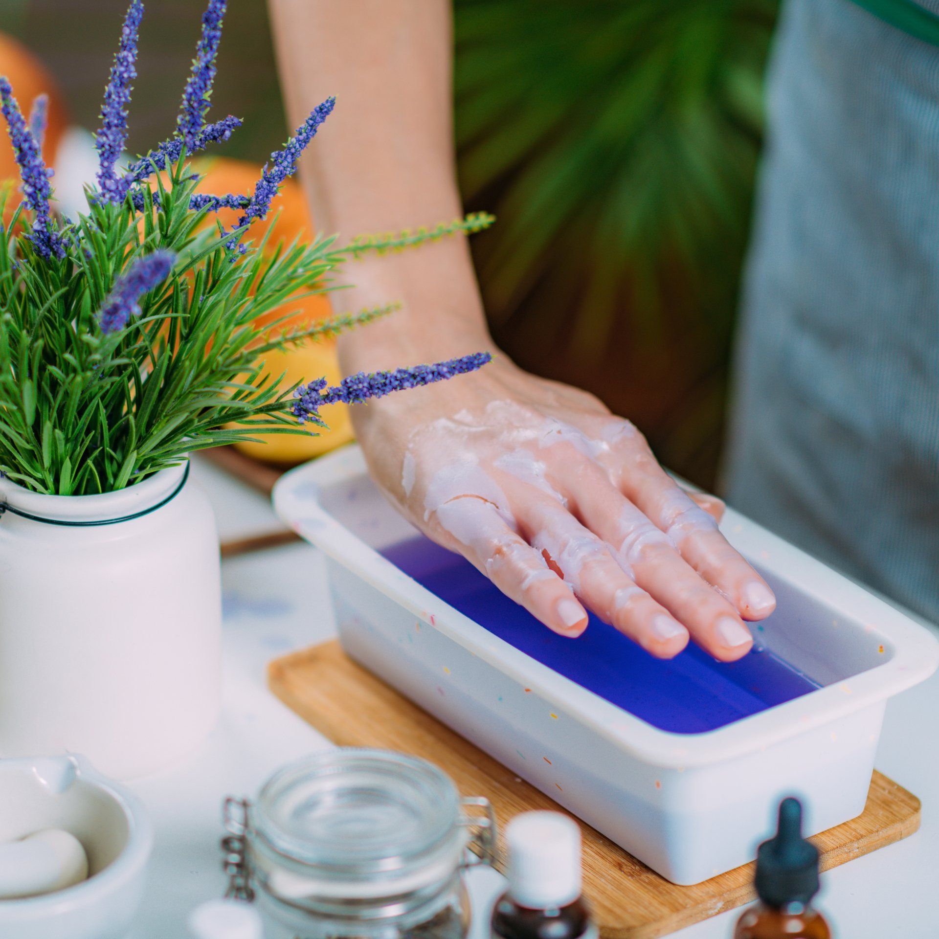 A woman 's hand is in a tray of blue liquid