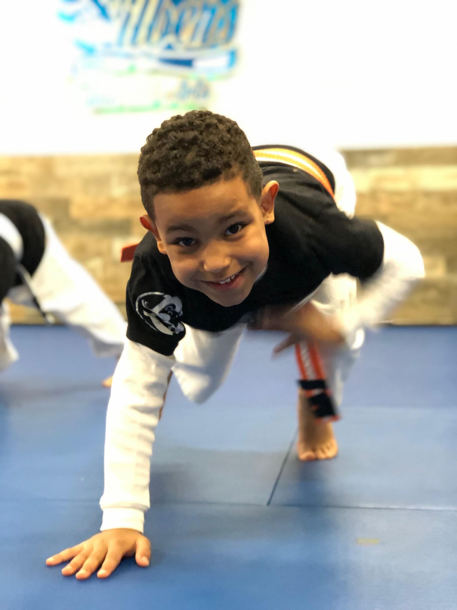 a young boy is doing a handstand on a blue mat .