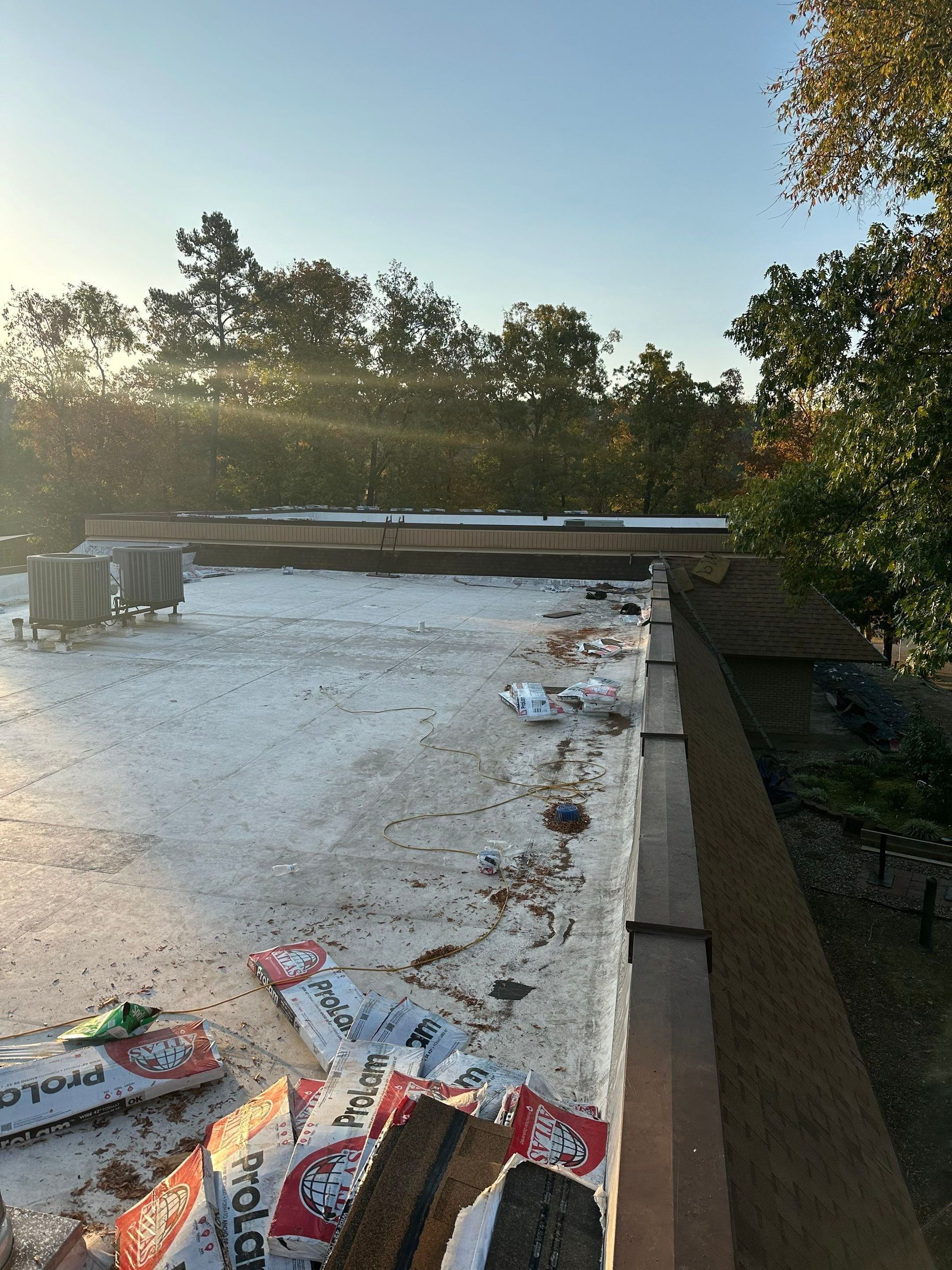 A roof with a lot of bags on it and trees in the background
