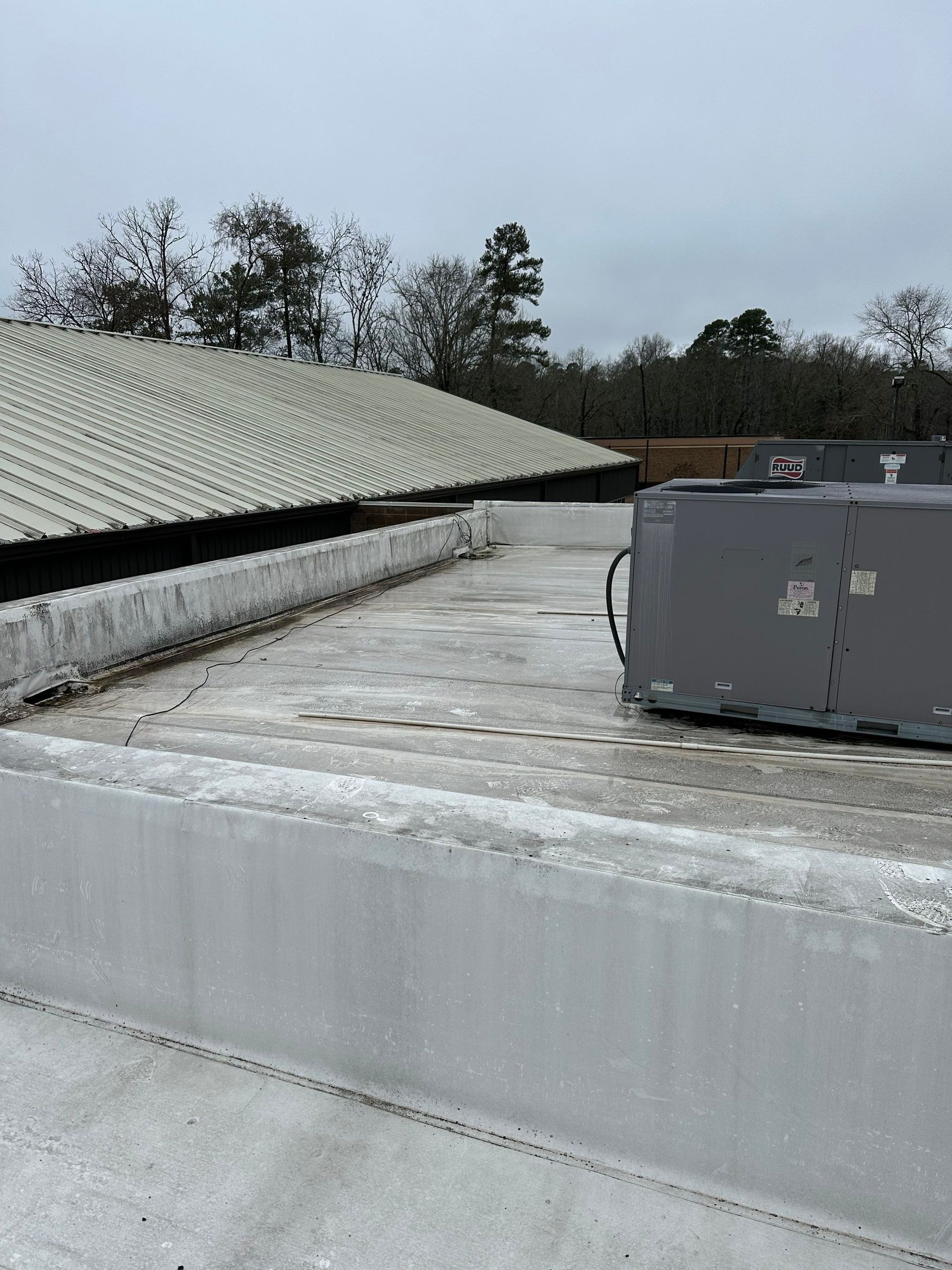 A large gray box is sitting on the roof of a building.