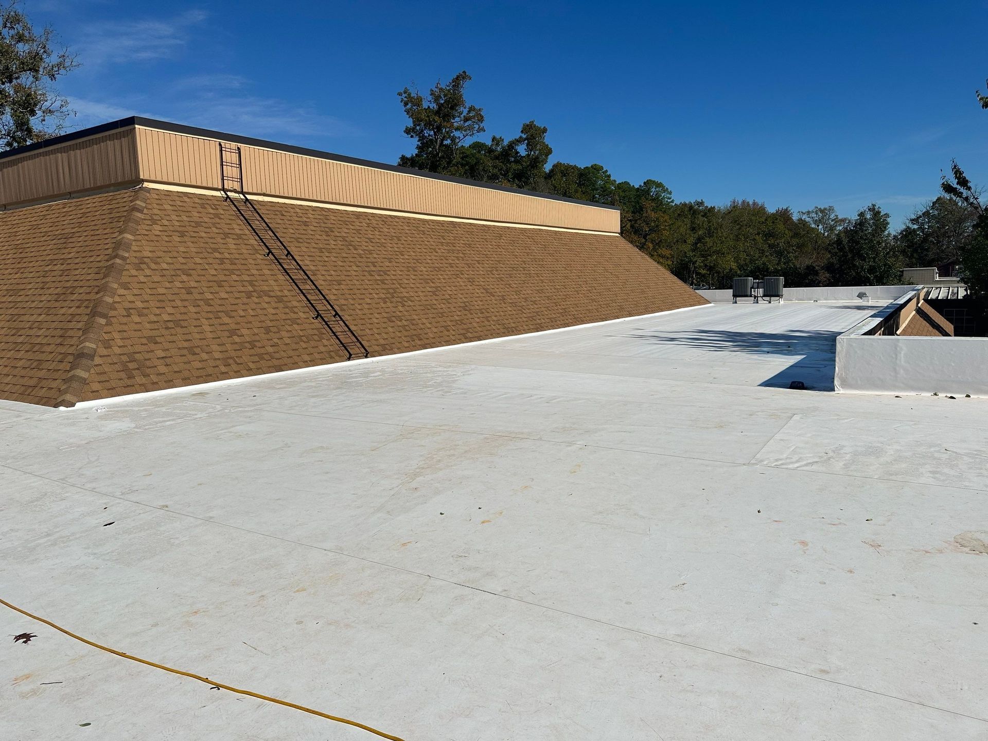 A white roof with a ladder on the side of it