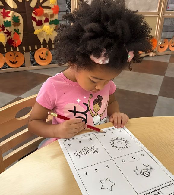 Montessori child working on sound recognition worksheet.