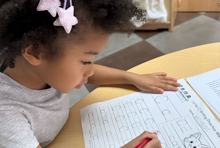 Montessori student tracing the letter C for handwriting practice.