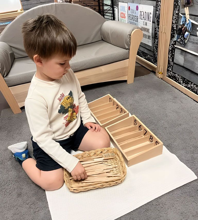 Child working with the Montessori Spindle Boxes.