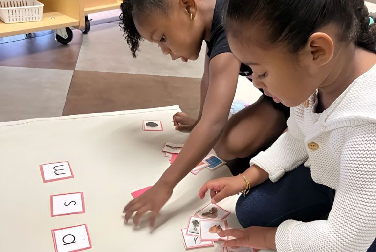 Montessori students matching language picture cards to letter sounds.
