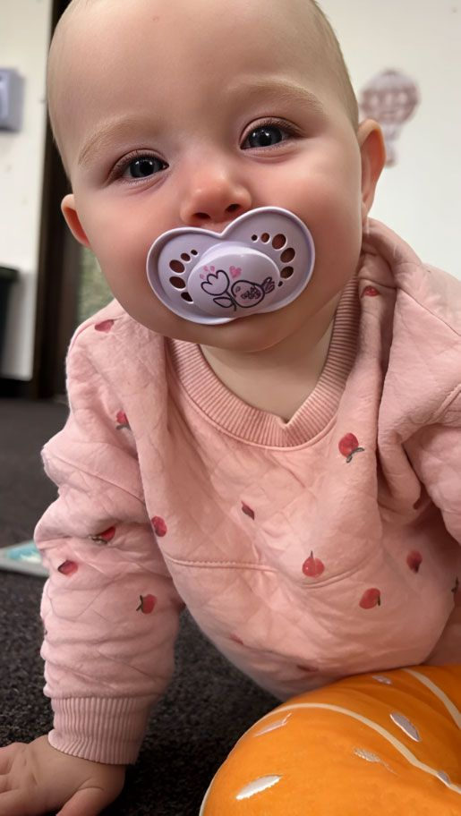 Montessori Infant with pacifier on the floor the Montessori Nido classroom