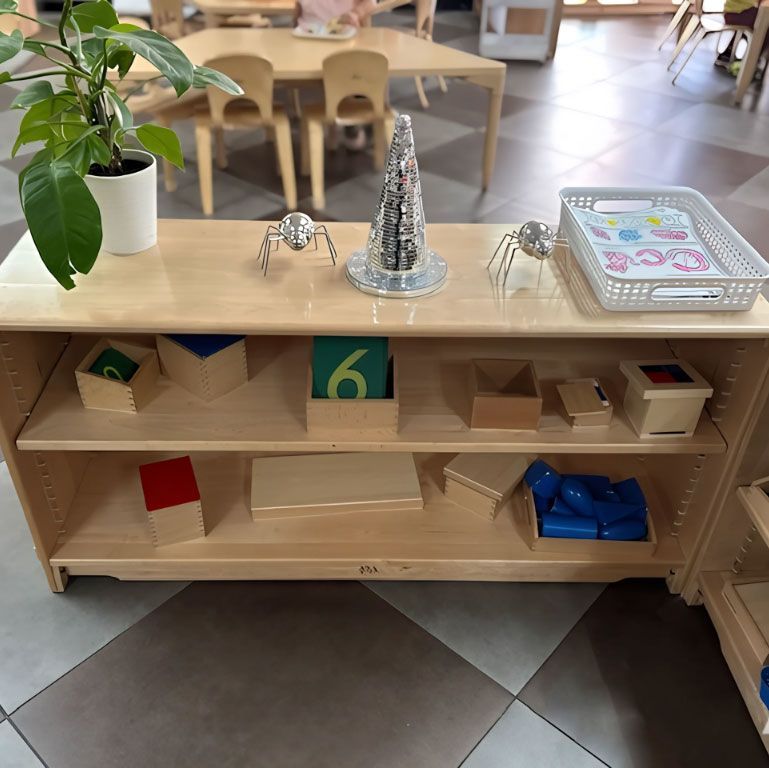 Montessori math shelf with the Number 6 box and geometric shapes.