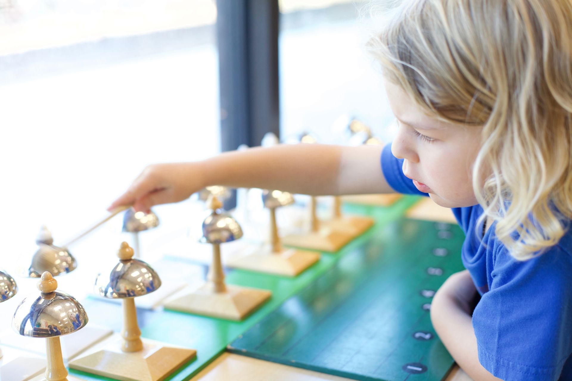 Child playing the Montessori bells.