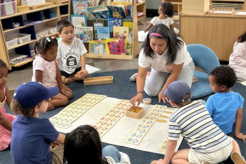 Montessori teacher giving a lesson with math materials.