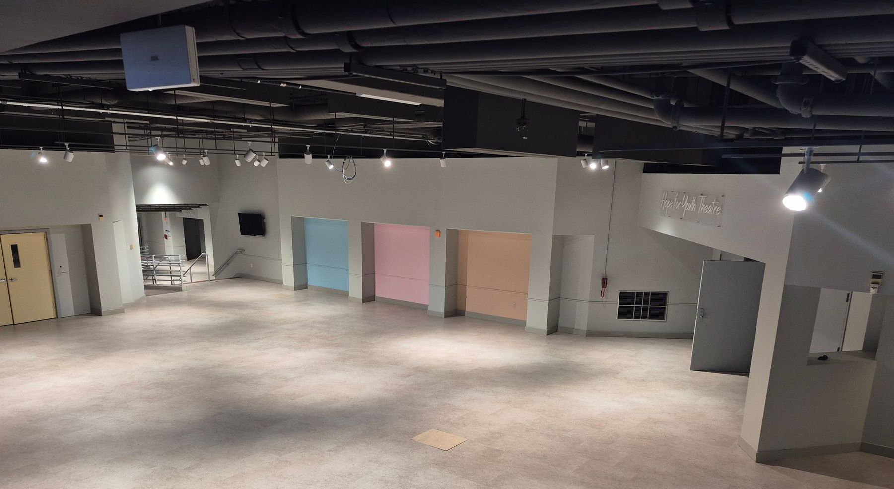 A large empty room with a lot of doors and lights.