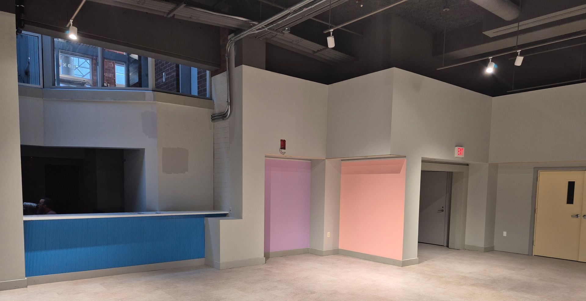 An empty room with pink and blue walls and a blue counter.