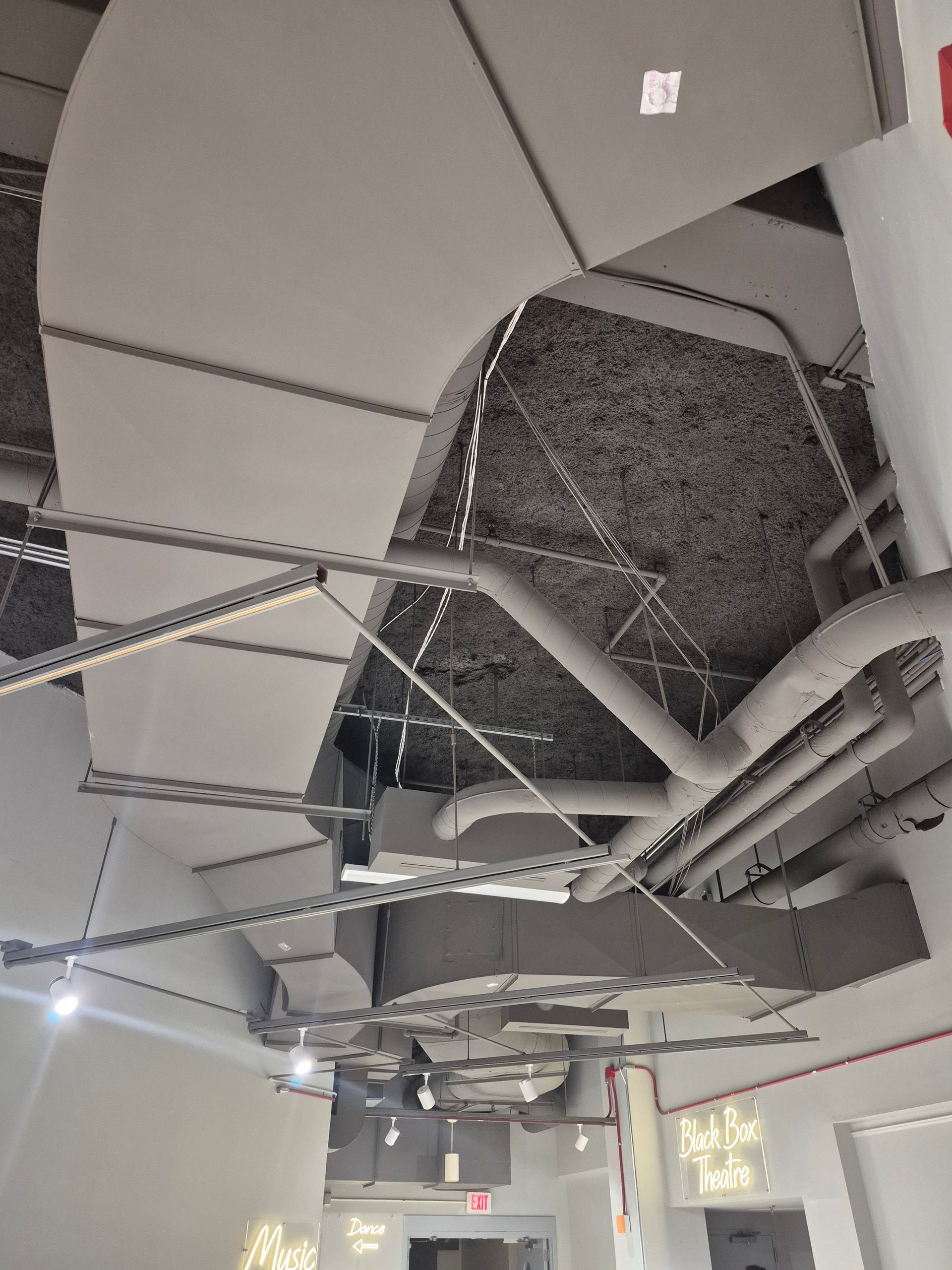 A ceiling with a lot of pipes coming out of it.