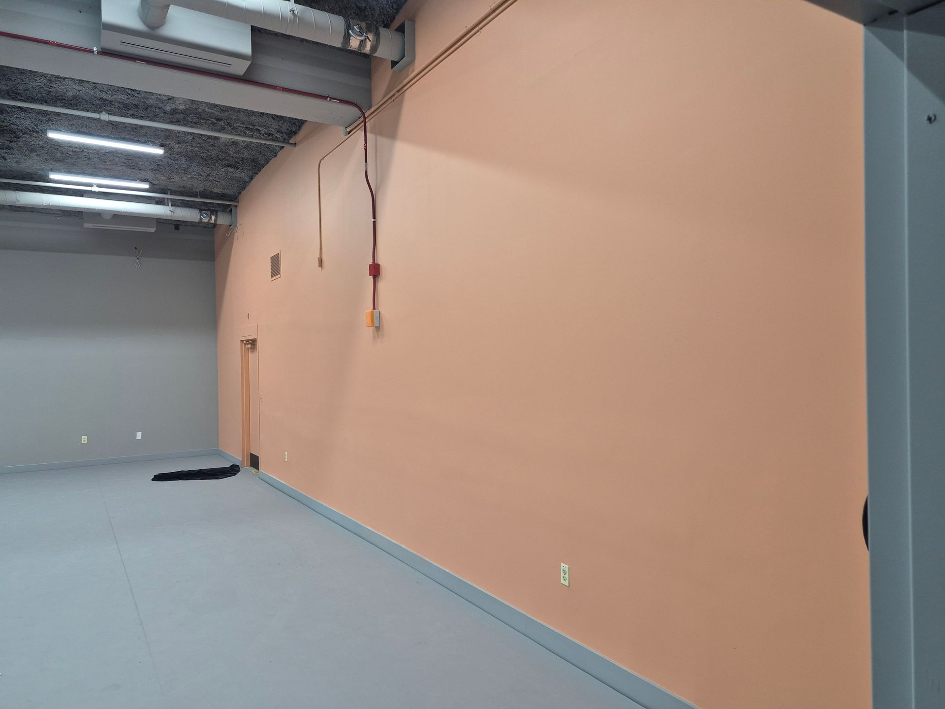 An empty room with a large wall and a door