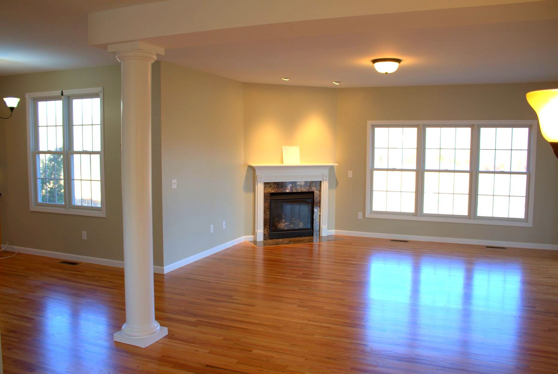 An empty living room with hardwood floors and a fireplace