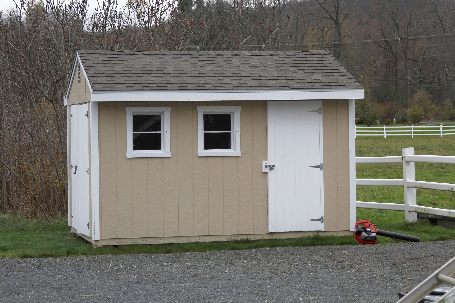 A small shed with a white door and two windows