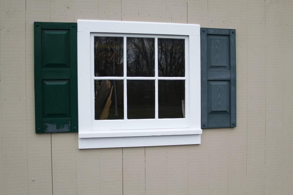 A window with green and blue shutters on it