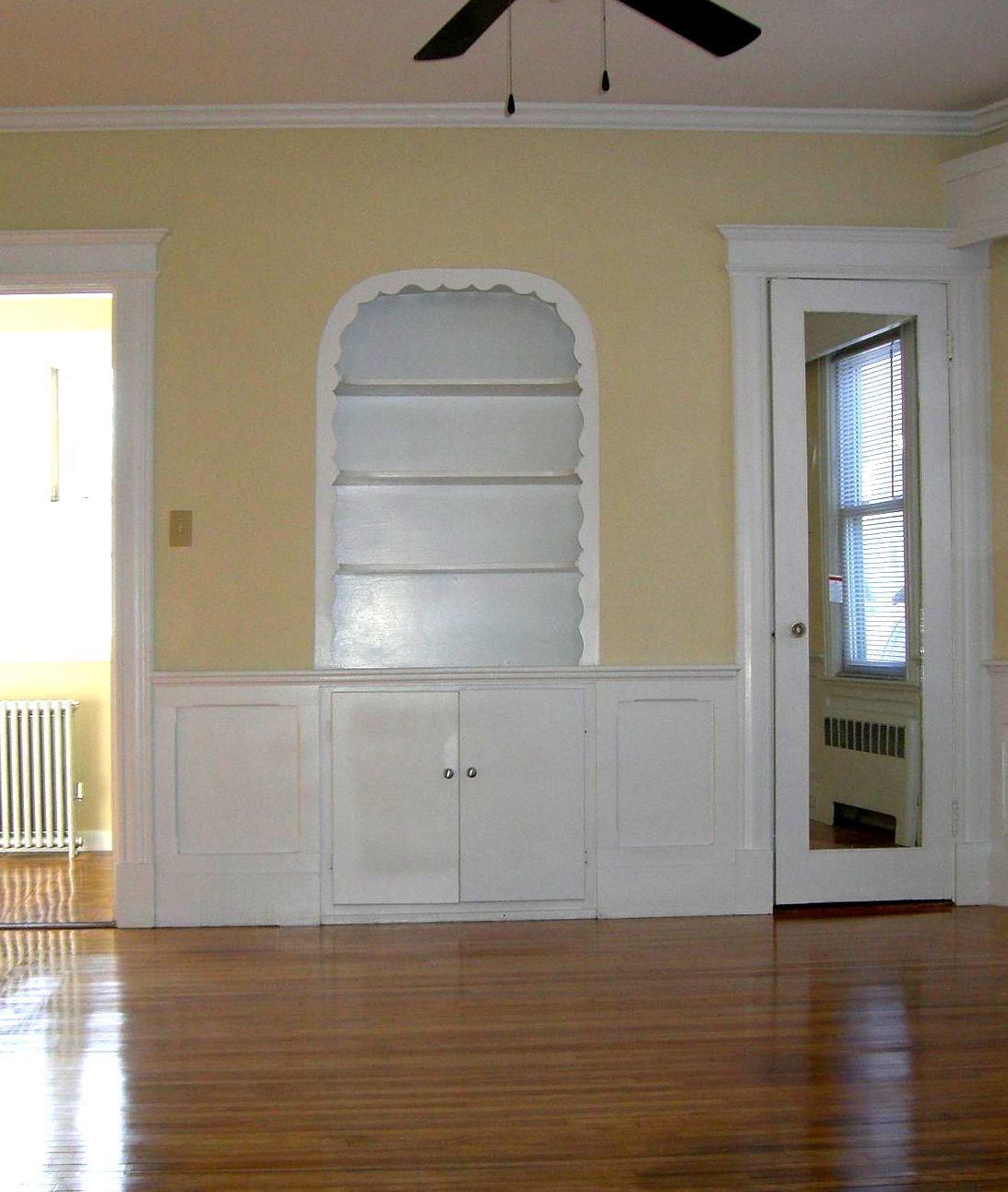 An empty room with a ceiling fan and a window