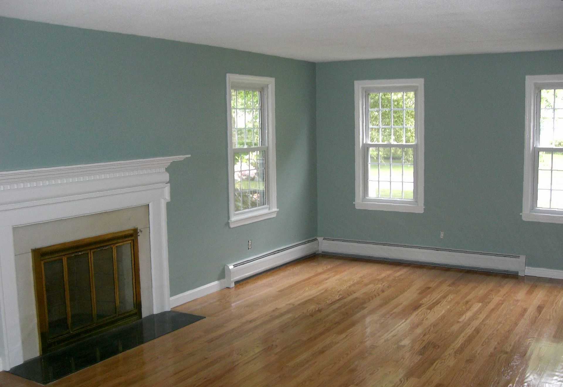 An empty living room with a fireplace and lots of windows