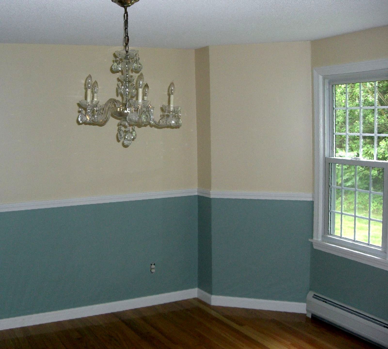 An empty room with a chandelier hanging from the ceiling