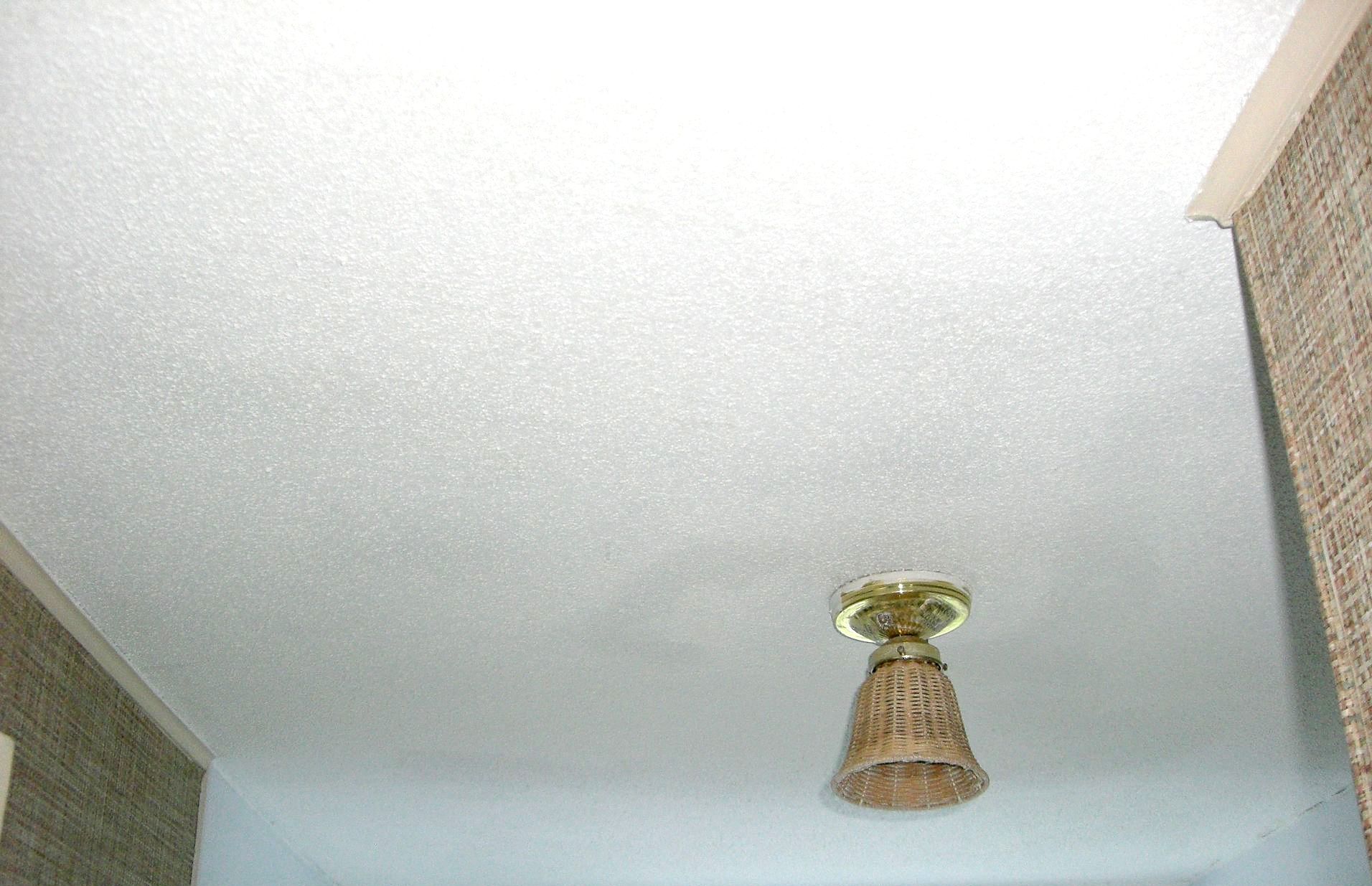 A light fixture is hanging from the ceiling in a hallway.
