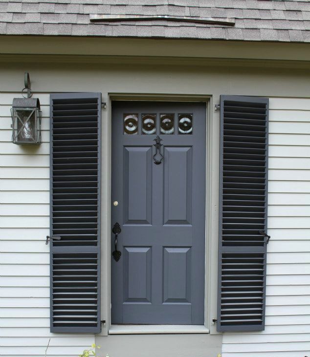 A white house with a gray door and black shutters