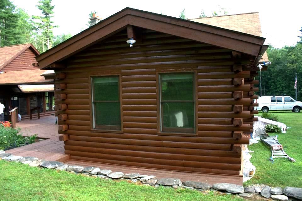 A log cabin is sitting in the middle of a lush green field.
