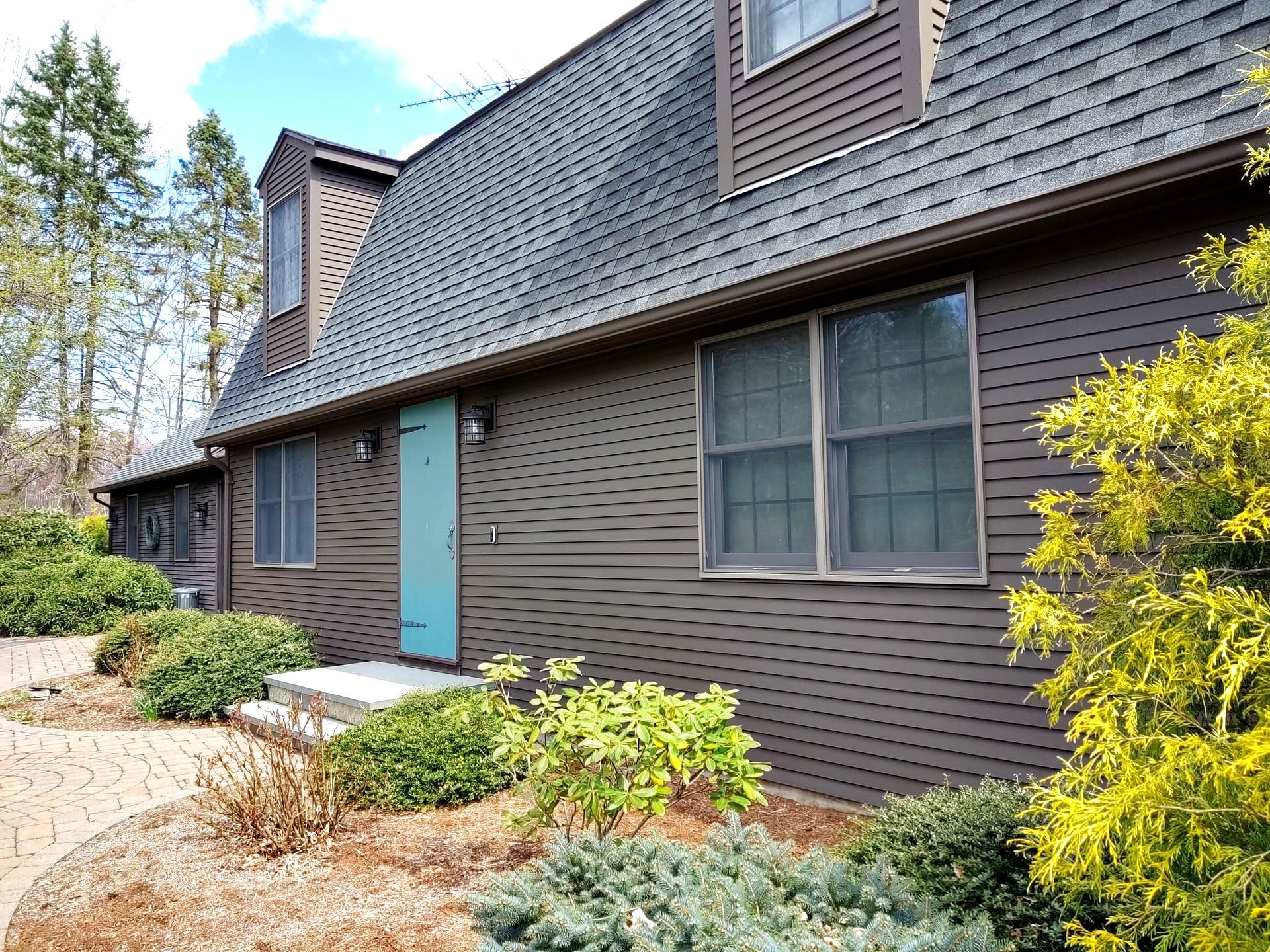 A house with a blue door and a black roof