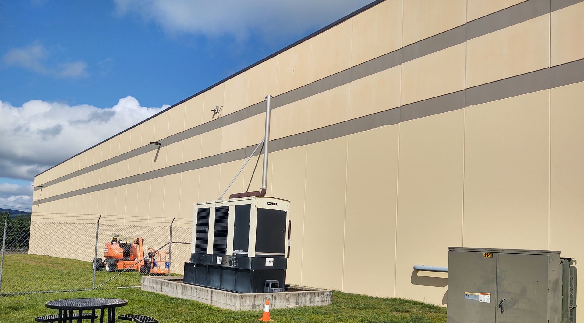 A large building with a lot of machinery in front of it.