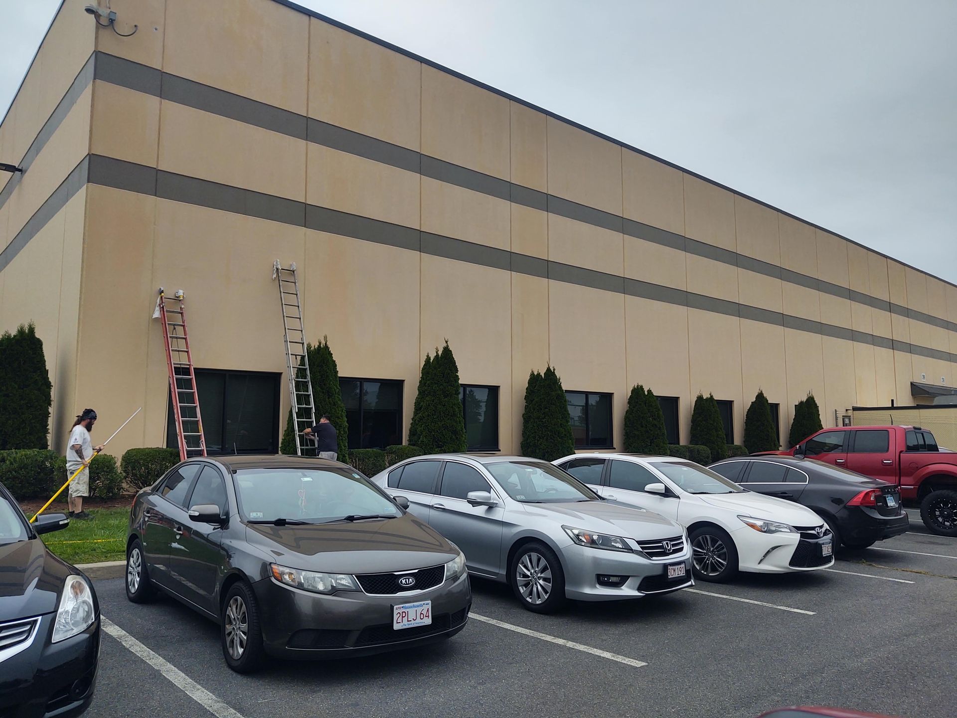 A row of cars are parked in front of a large building