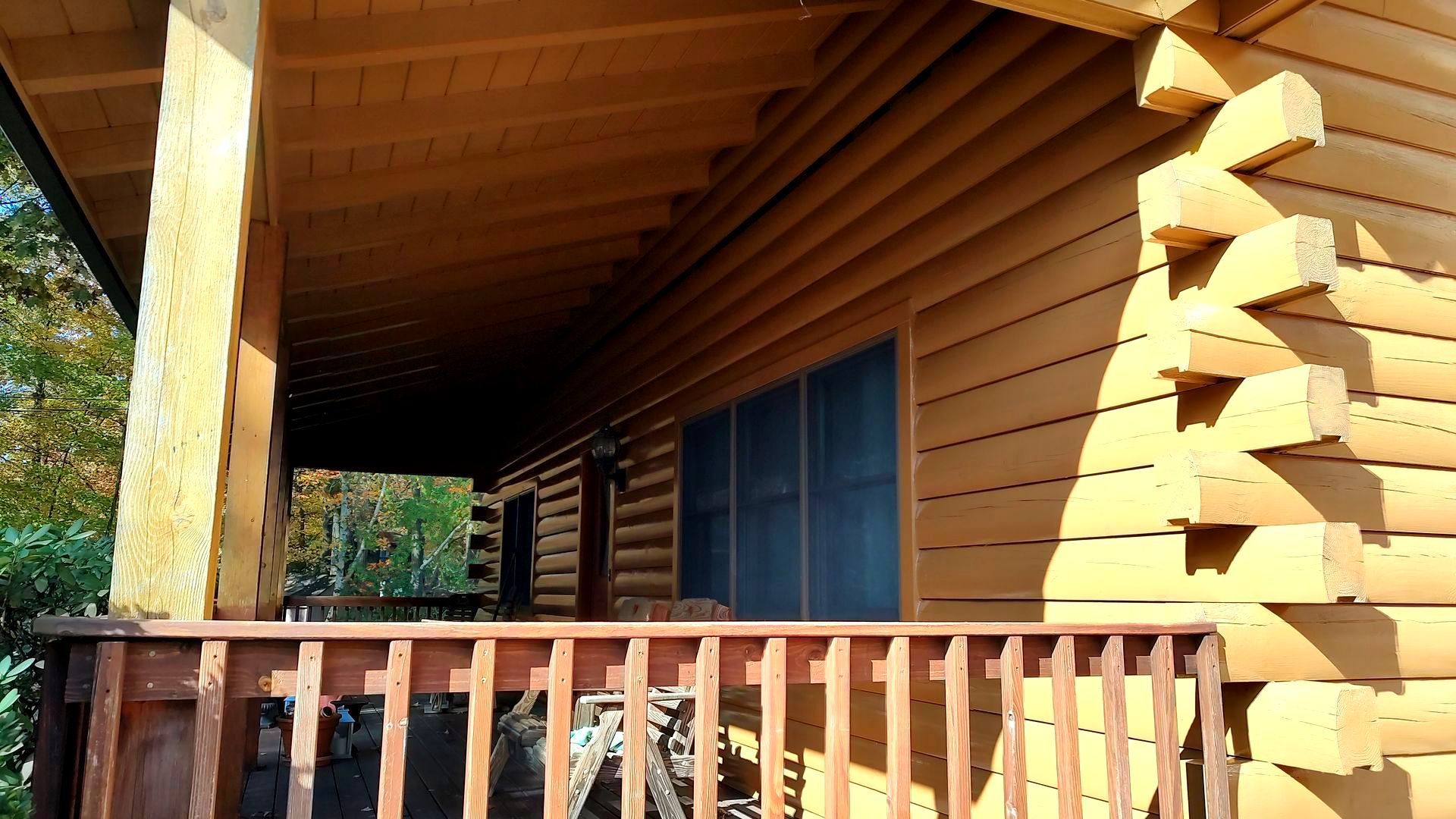 A log cabin with a porch and a railing