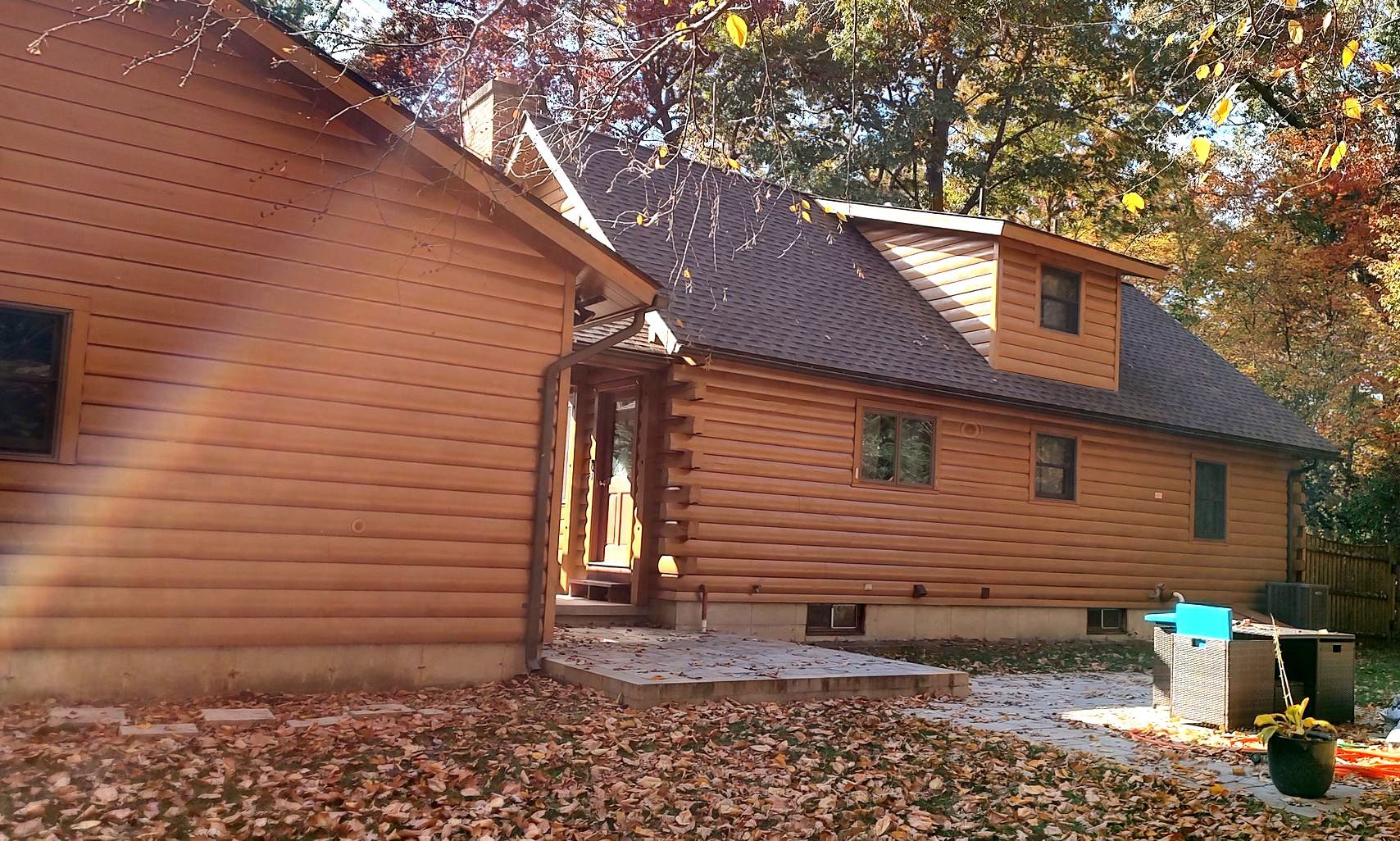 A log cabin in the woods with the sun shining through the trees