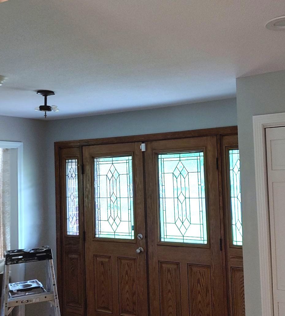 A wooden door with stained glass windows in a room.