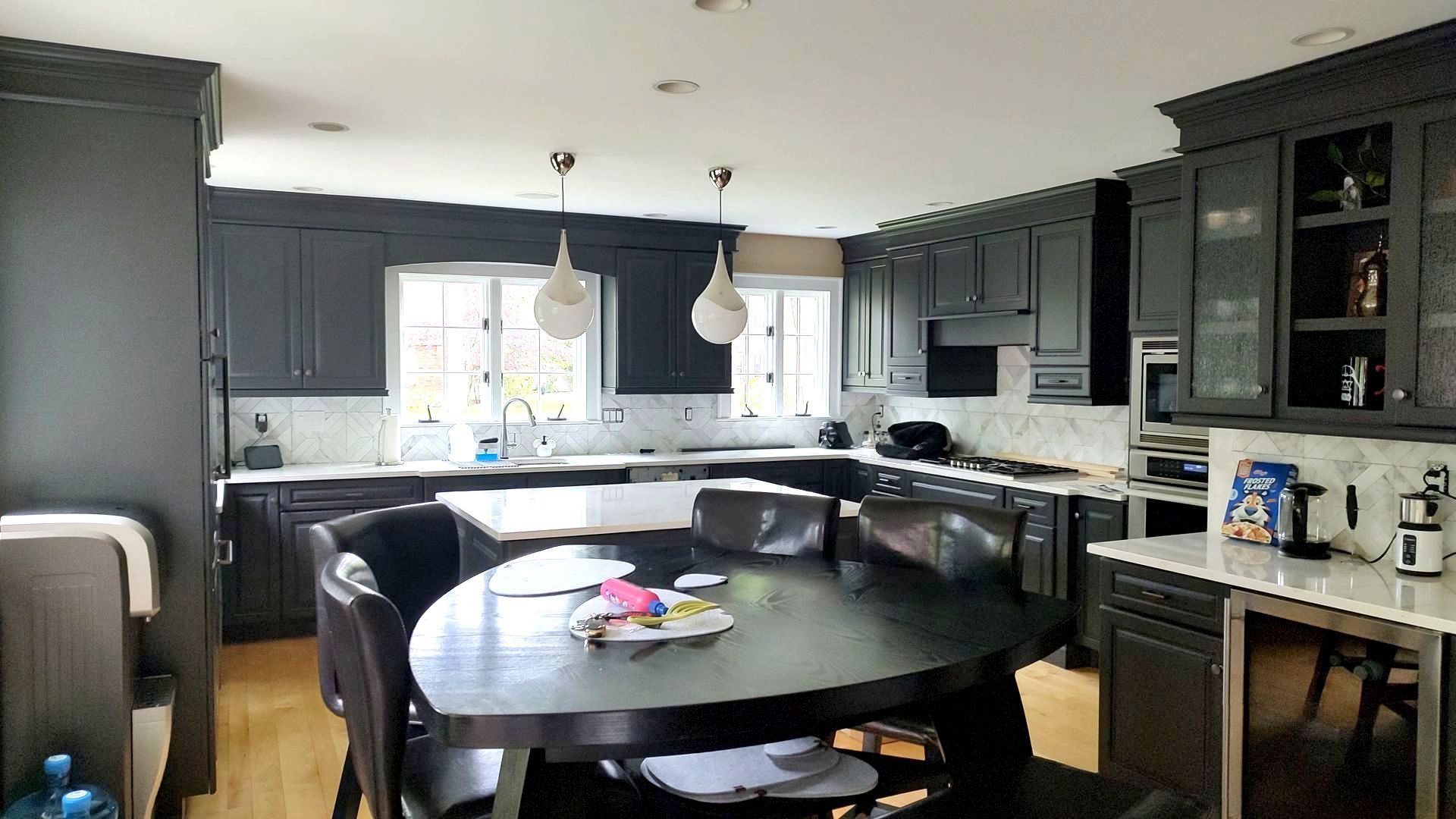 A kitchen with a round table and chairs in it.