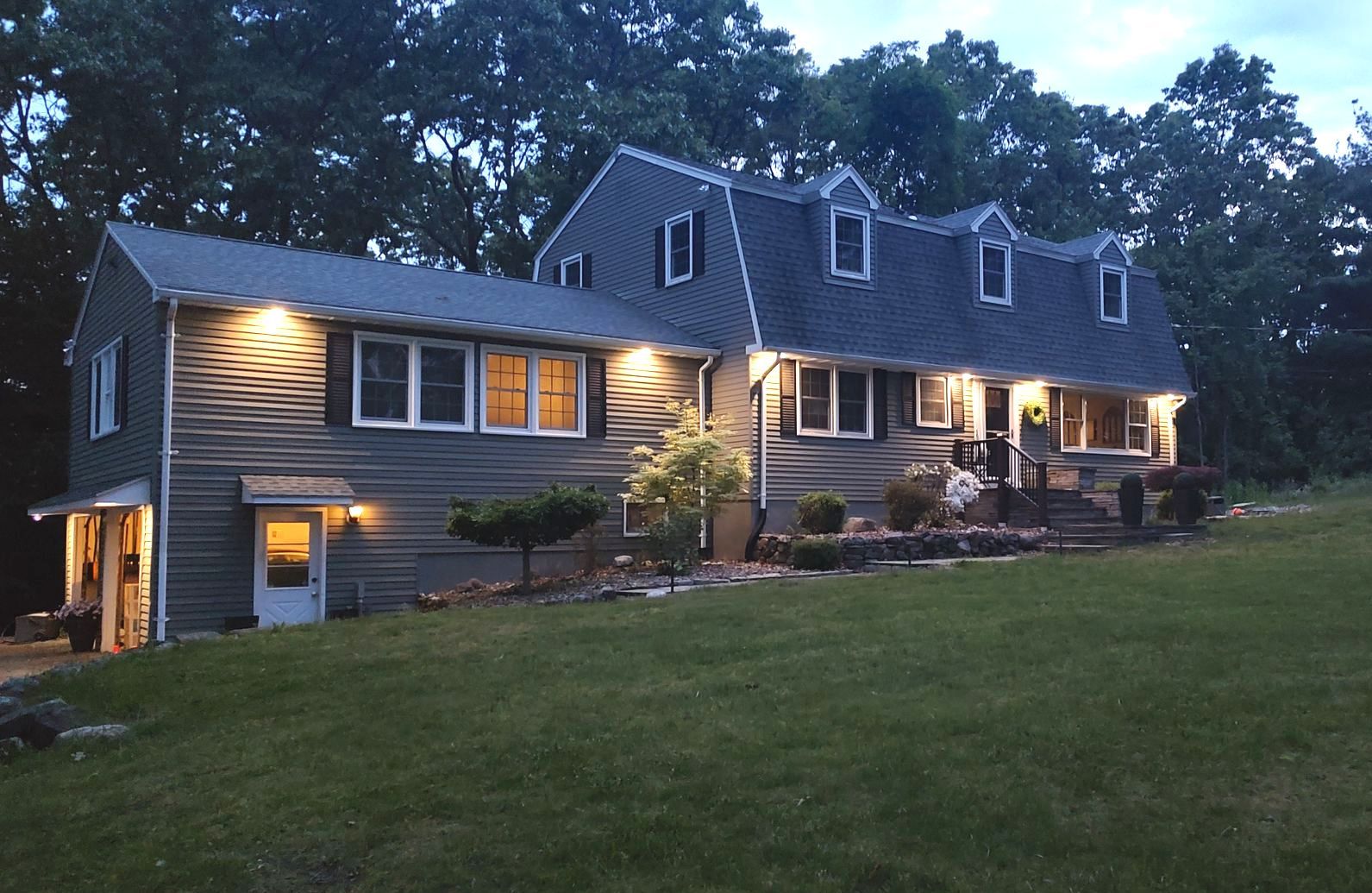 A large house with a lot of windows is lit up at night