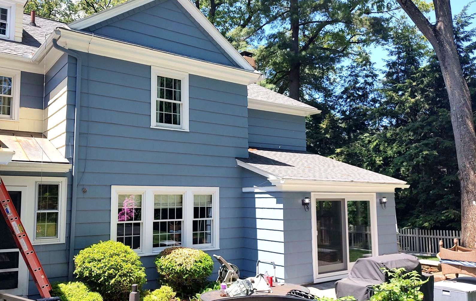 A blue house with a ladder in front of it