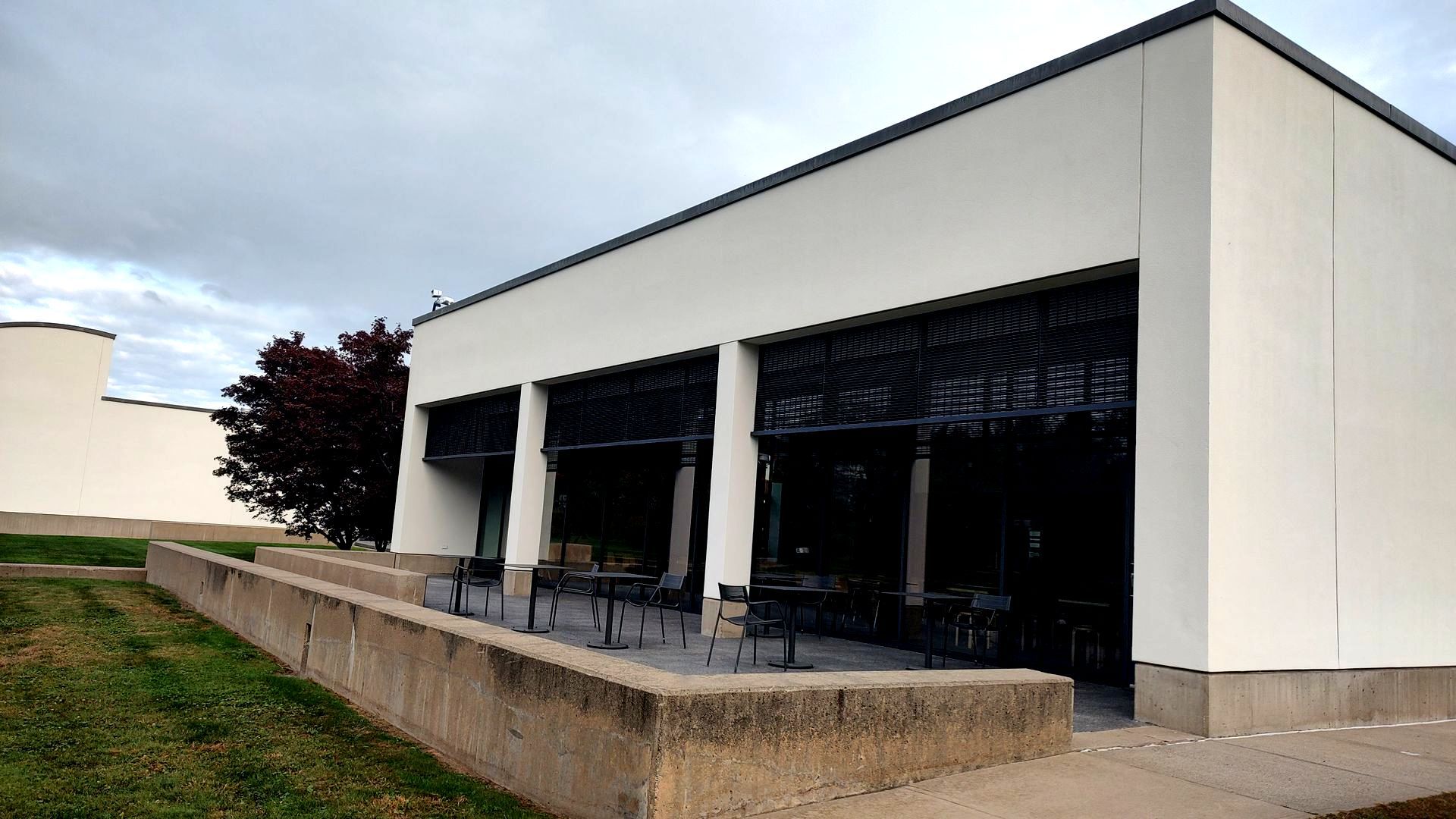 A white building with a black awning on the side
