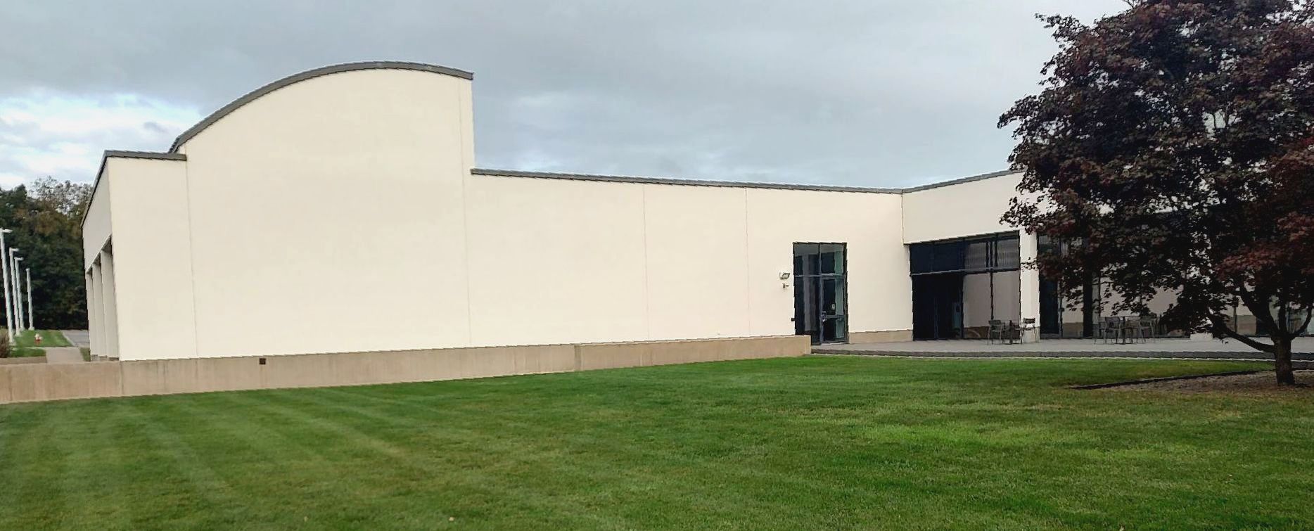 A large white building with a tree in front of it