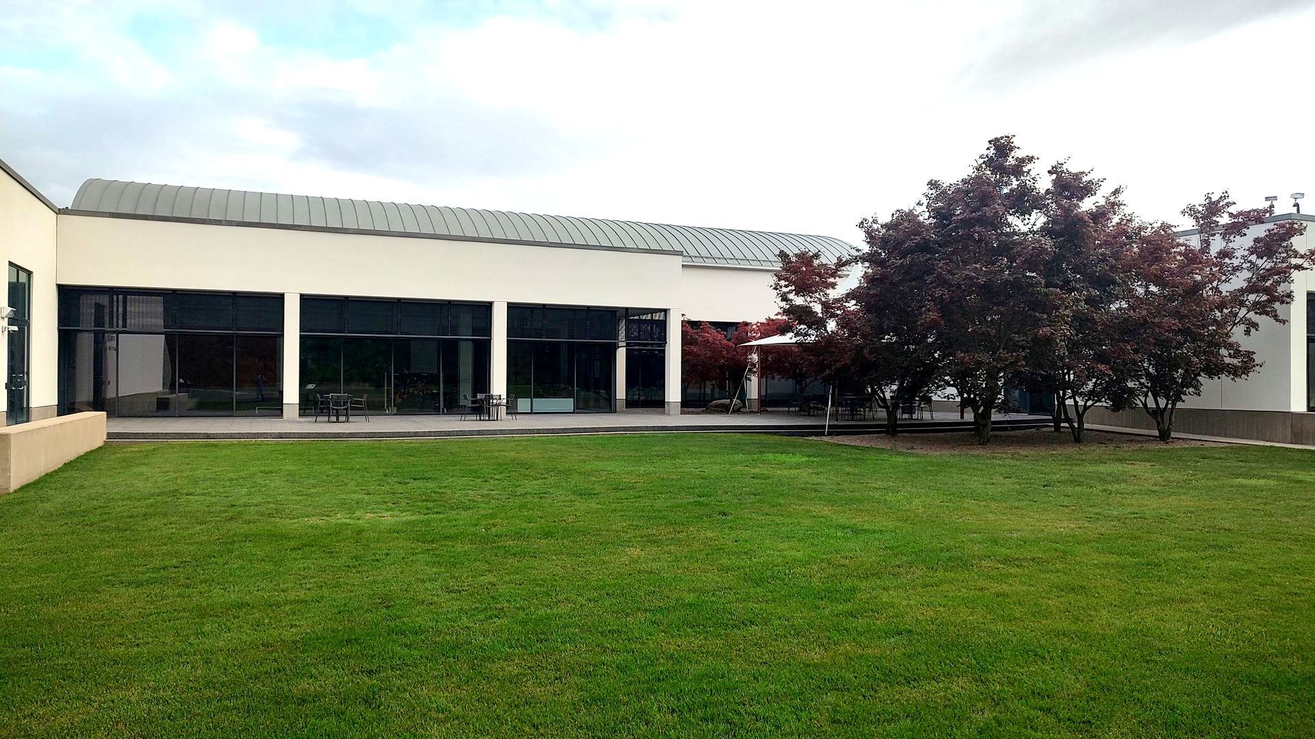 A large white building with a large lawn in front of it.