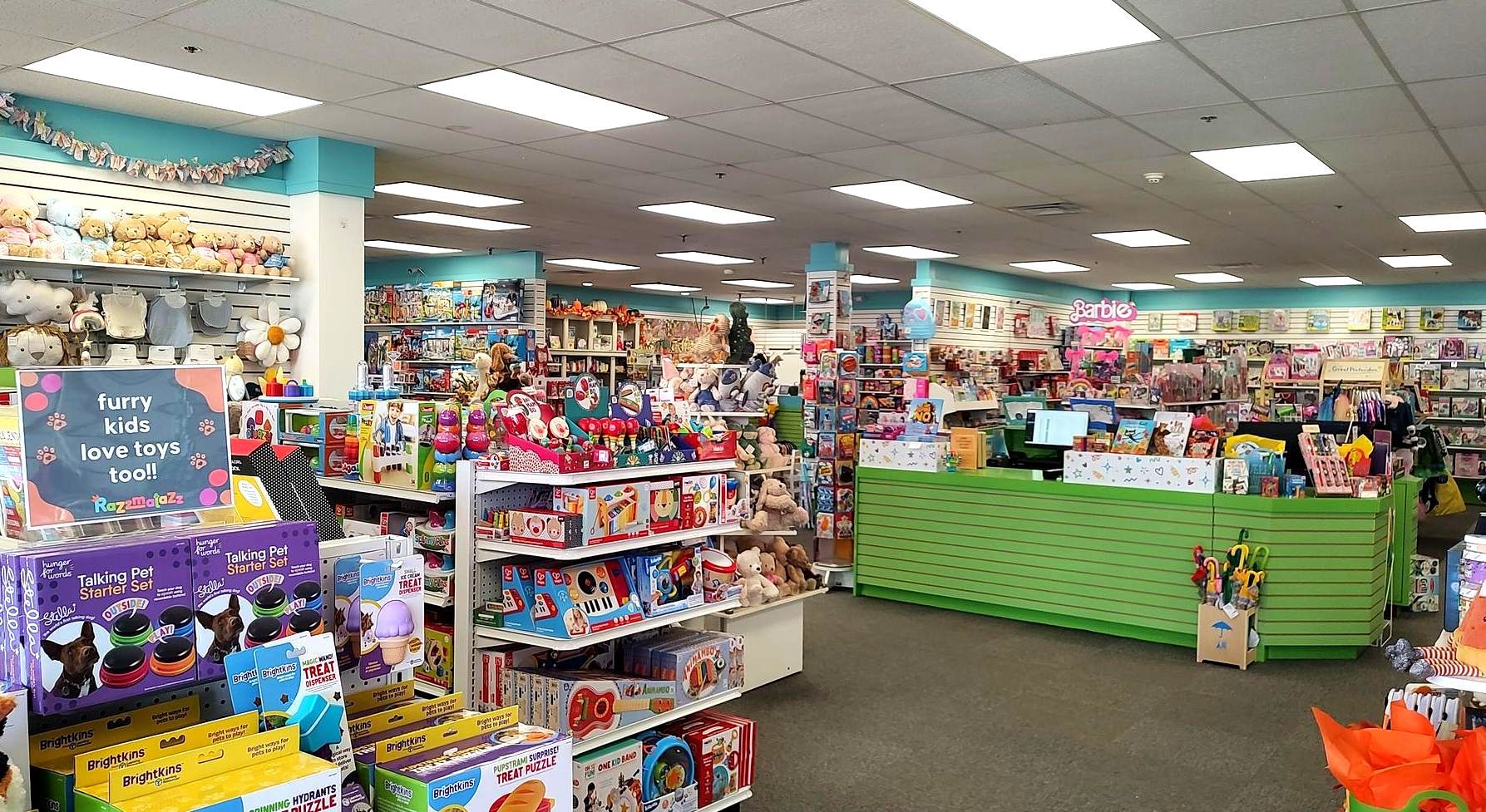 A toy store filled with lots of toys and a green counter.