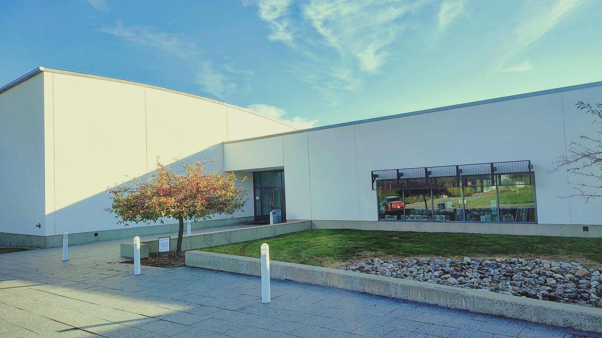 A large white building with a tree in front of it.