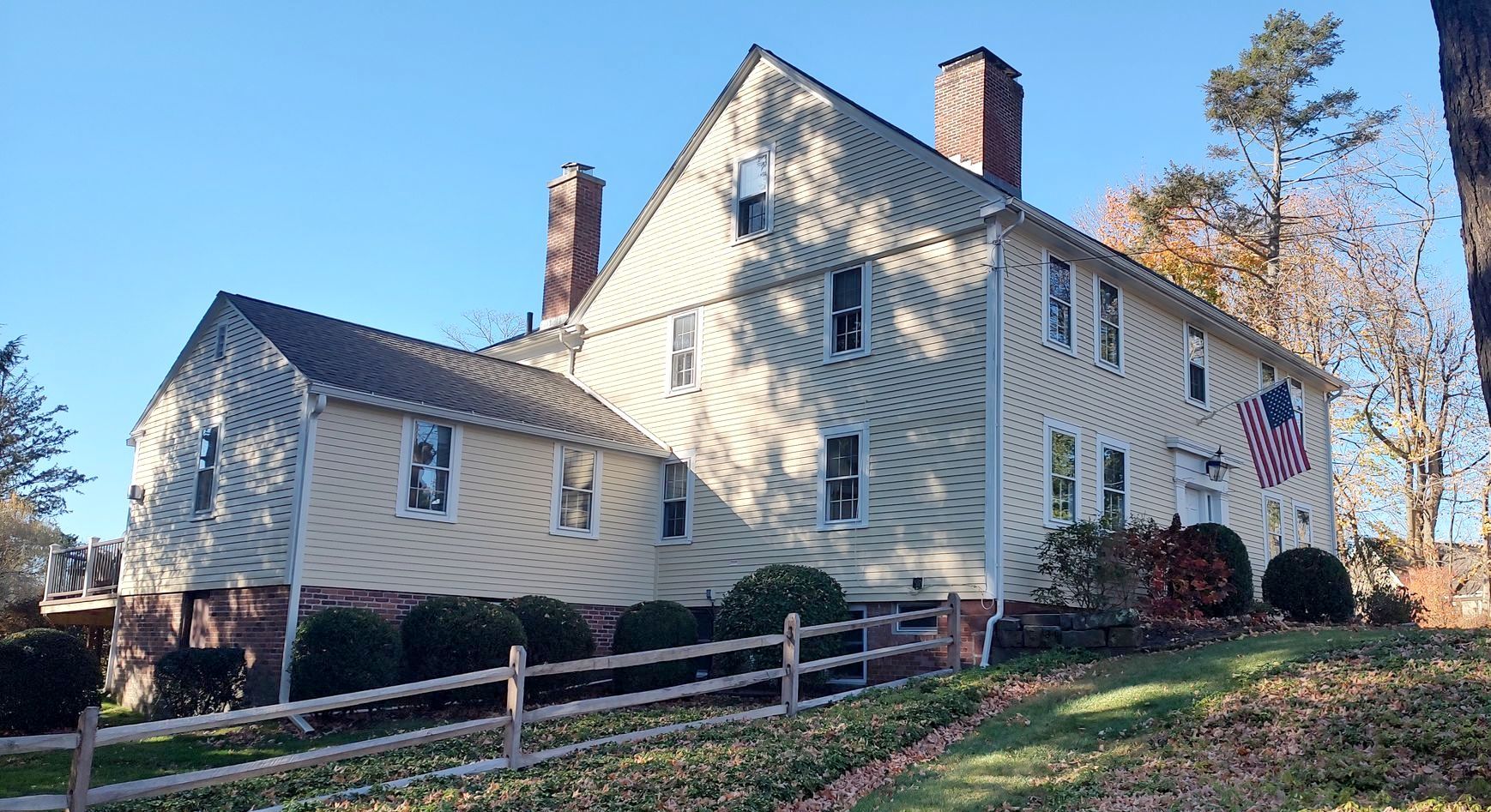 A large white house with a fence in front of it