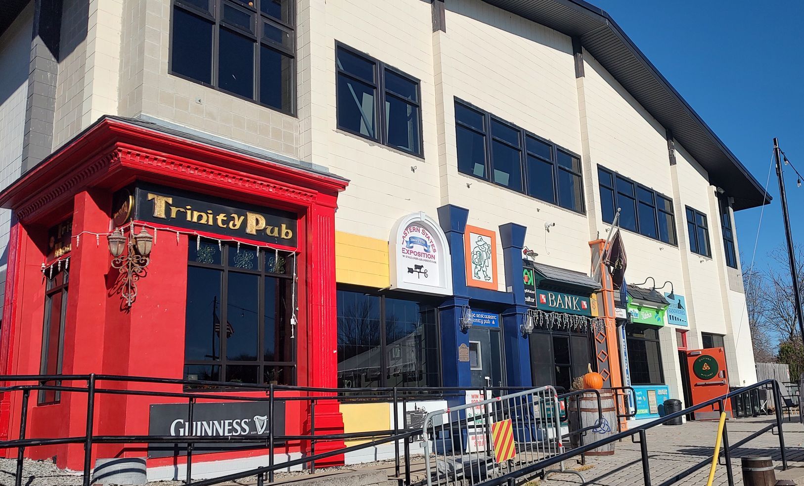 A large building with a red door and a sign that says trinity pub