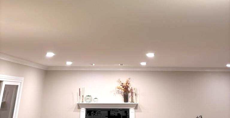 A living room with a fireplace and a ceiling light.