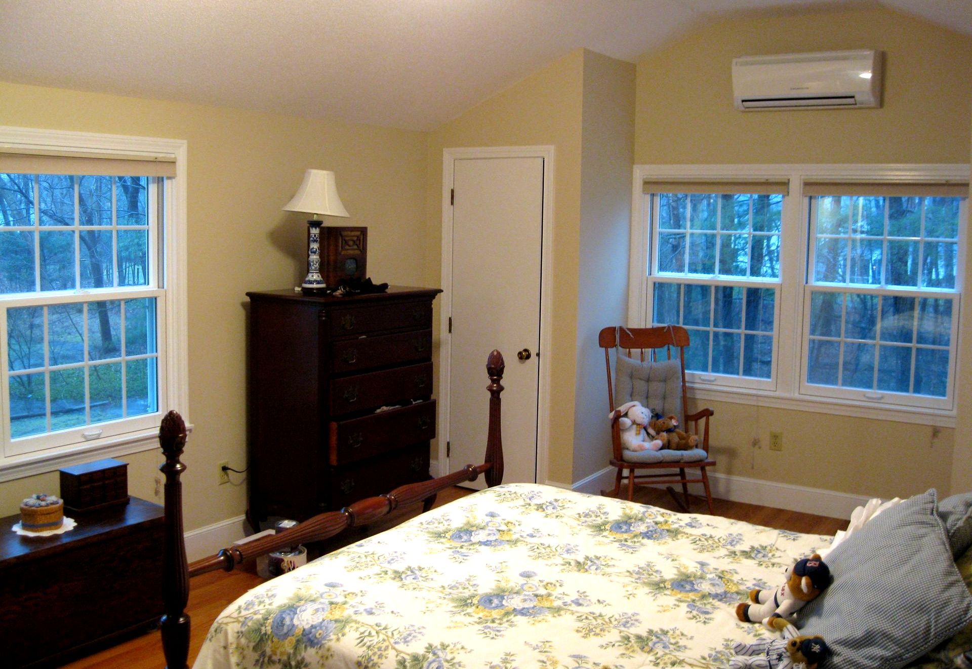 A bedroom with a large bed and a rocking chair
